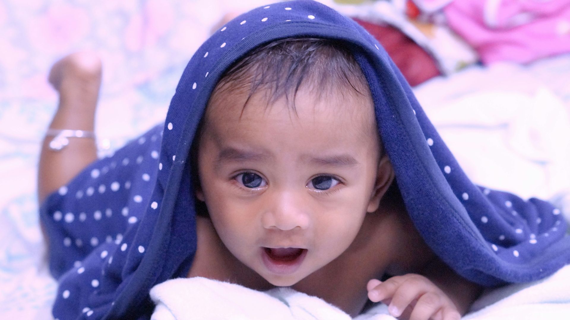 baby in white and blue polka dot blanket
