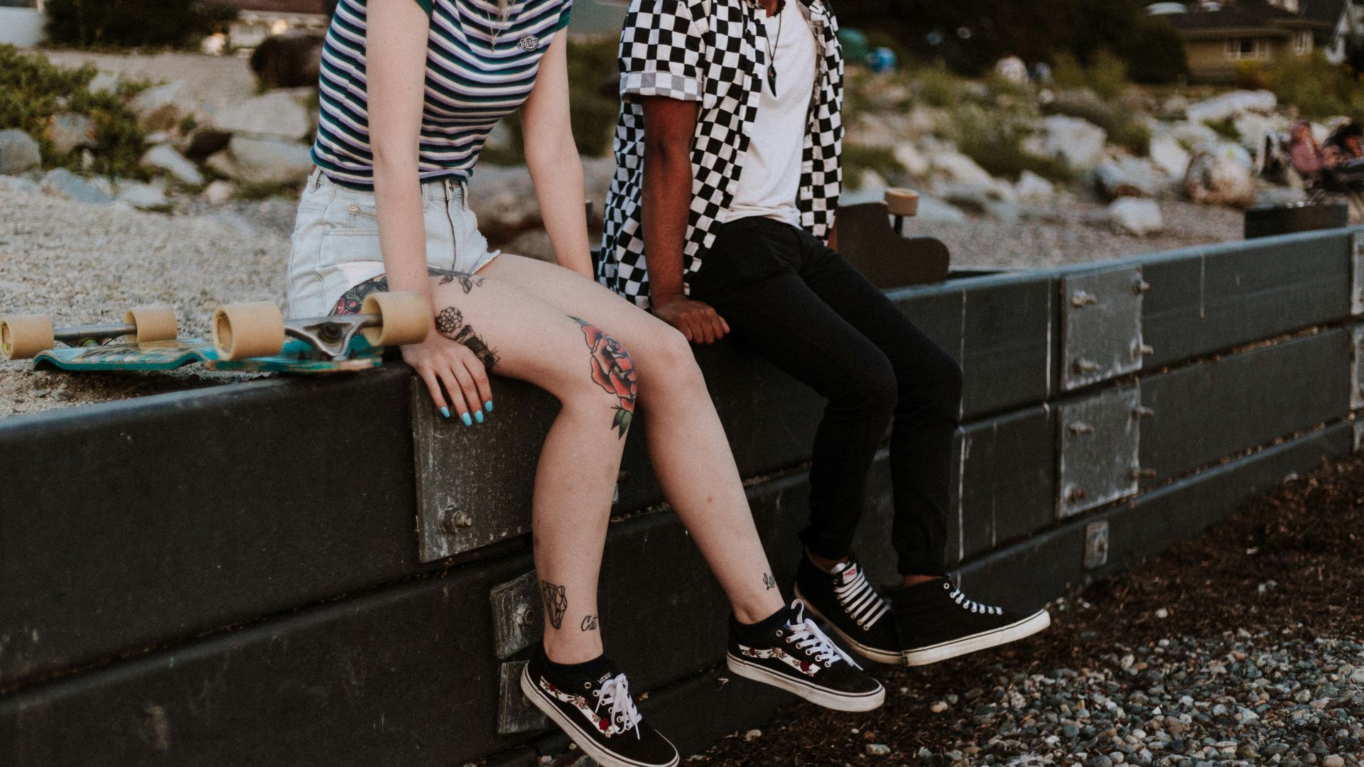 two person sits on fence
