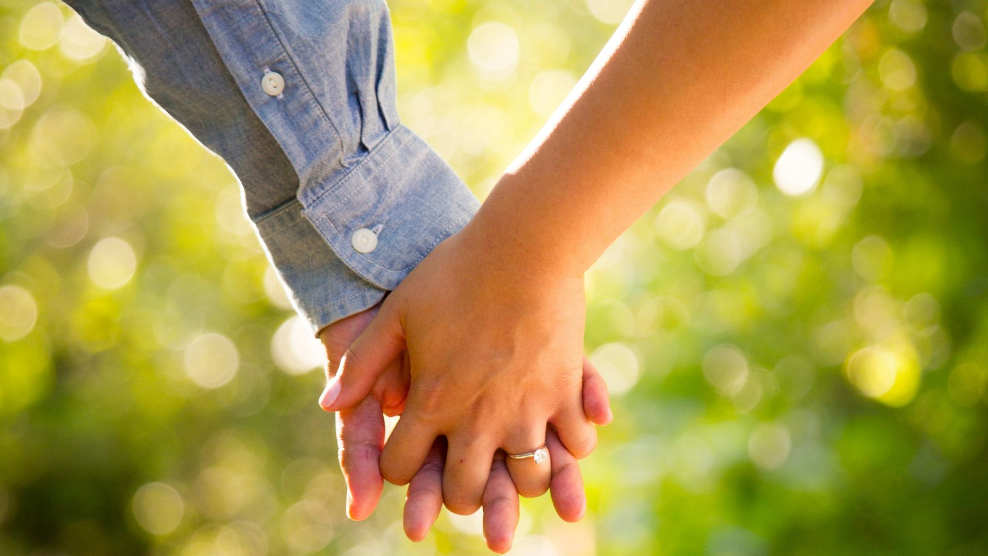shallow focus photo of man and woman holding hands