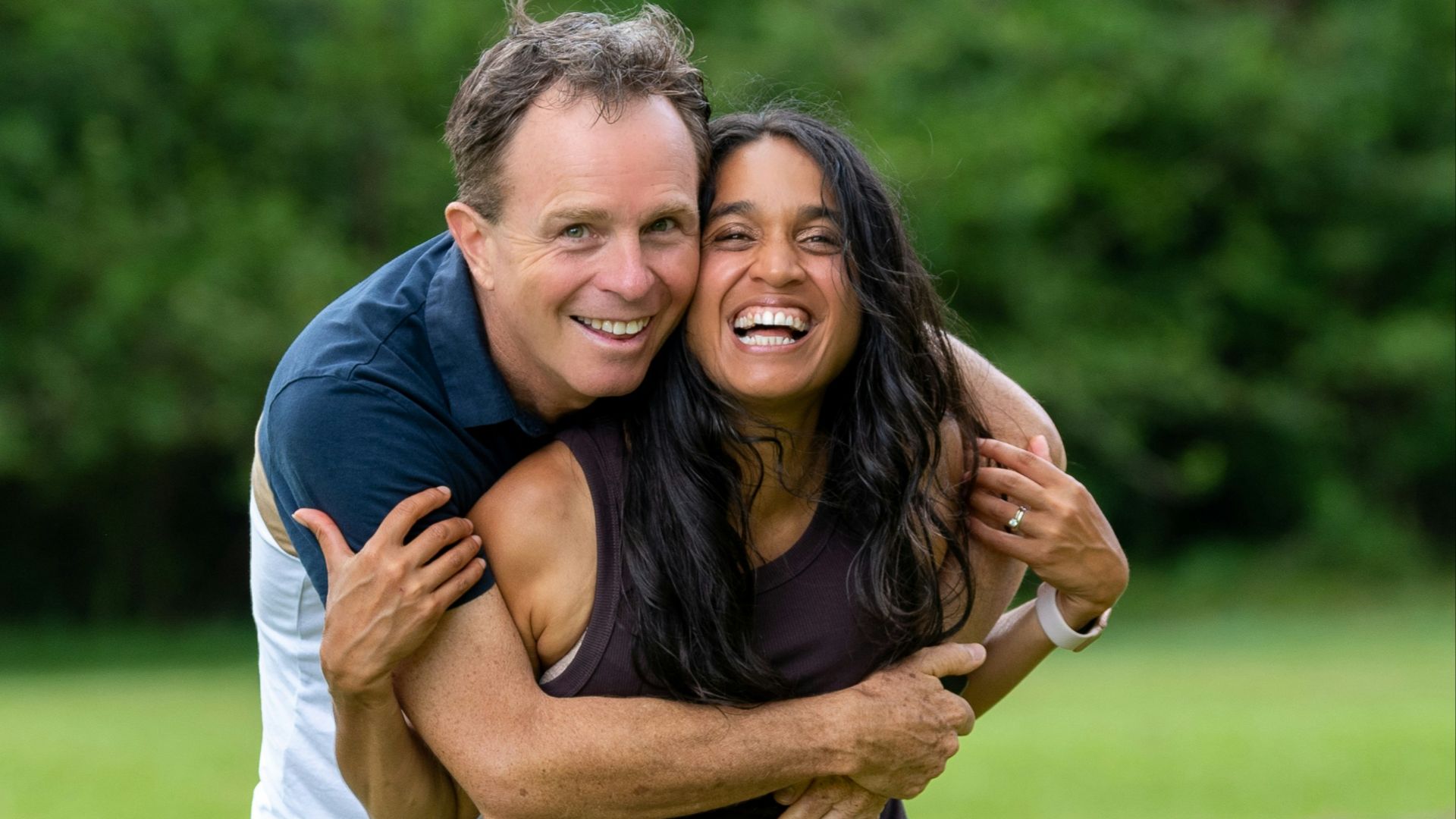 a man hugging a woman in a field
