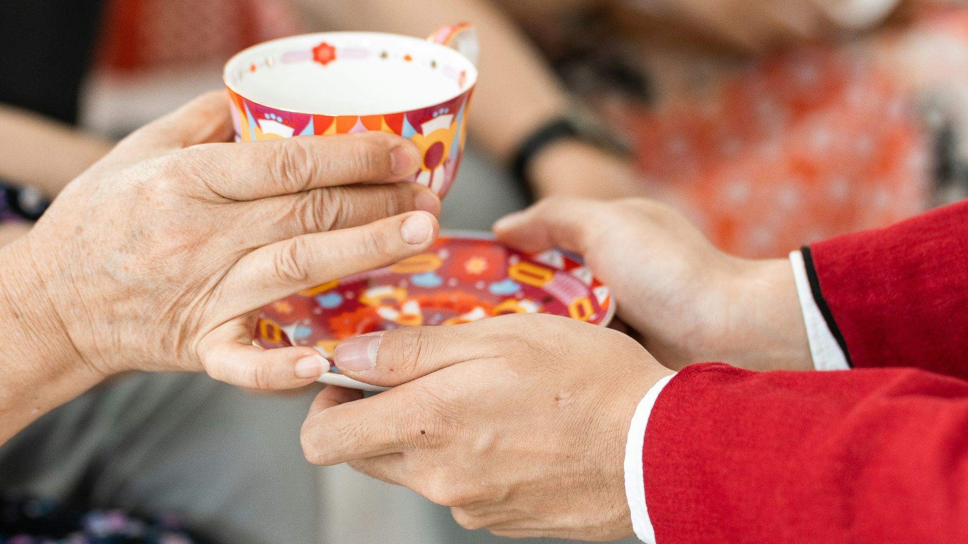 a man and a woman holding a cup in their hands