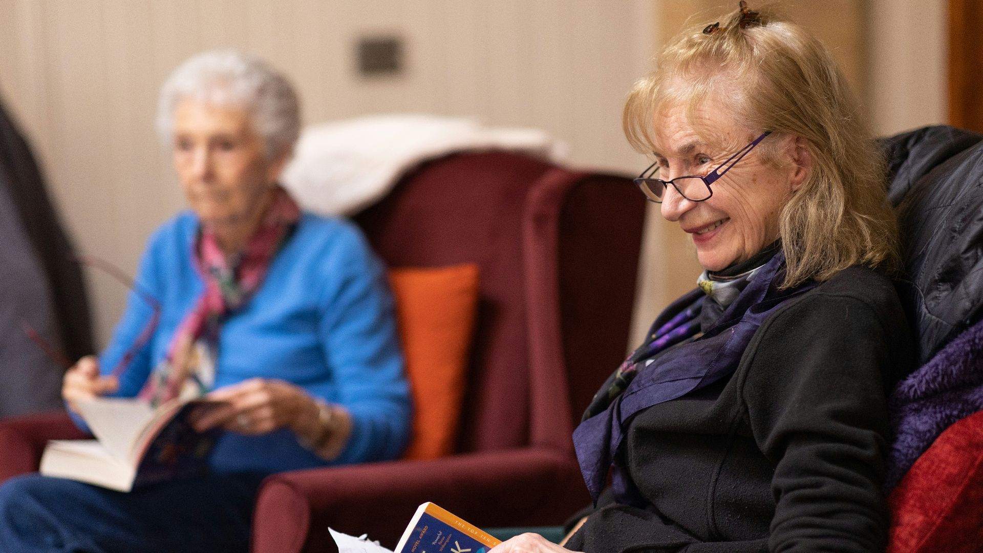 a woman sitting in a chair reading a book