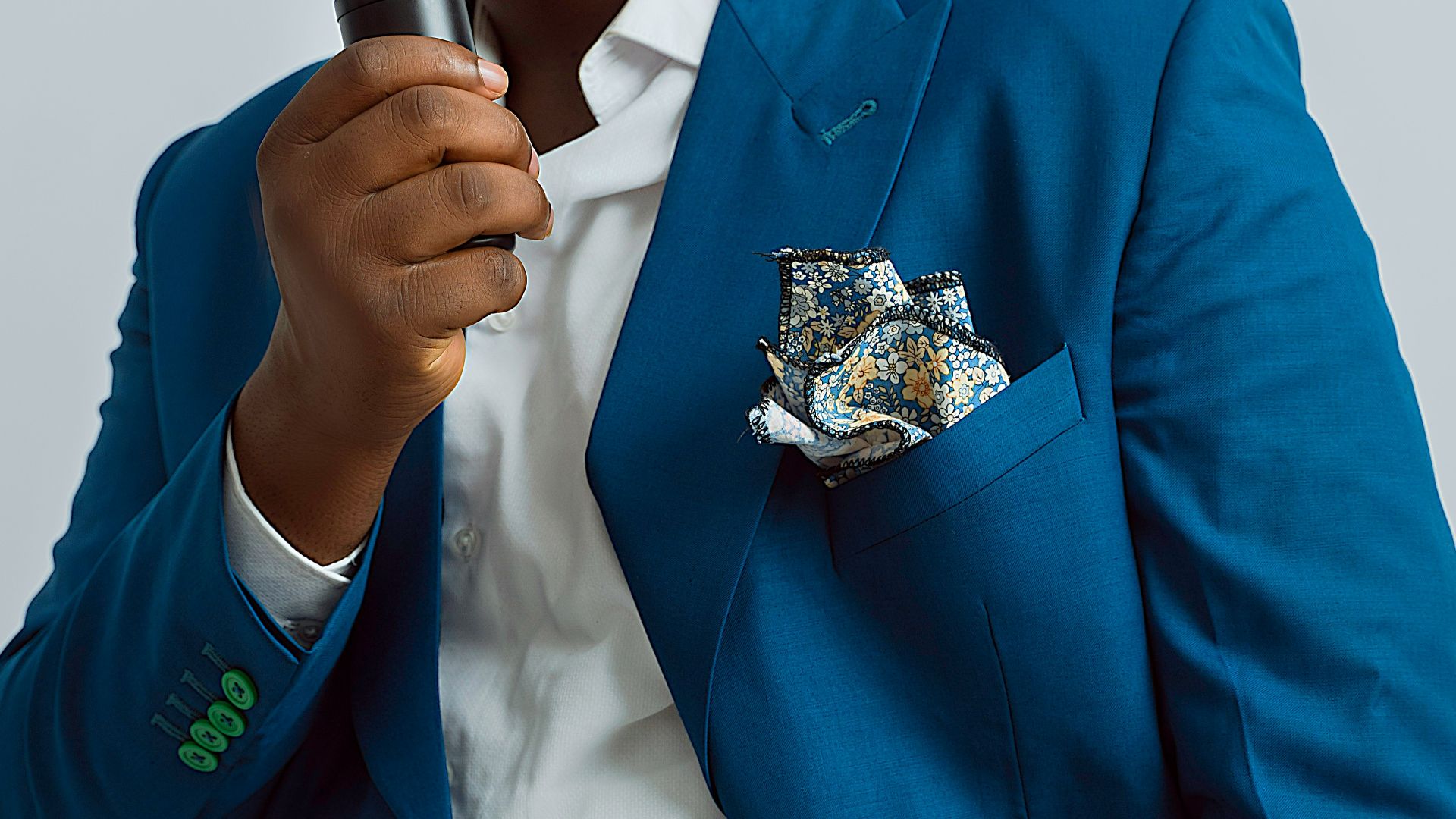 a man in a blue suit holding a microphone