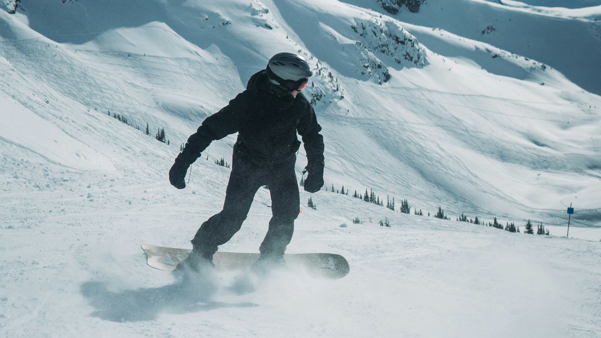 a man riding a snowboard down a snow covered slope