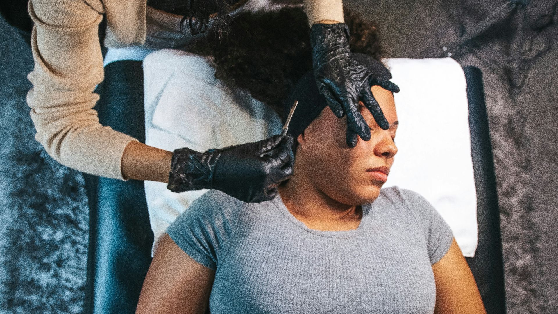 a woman getting her hair cut by a hair stylist