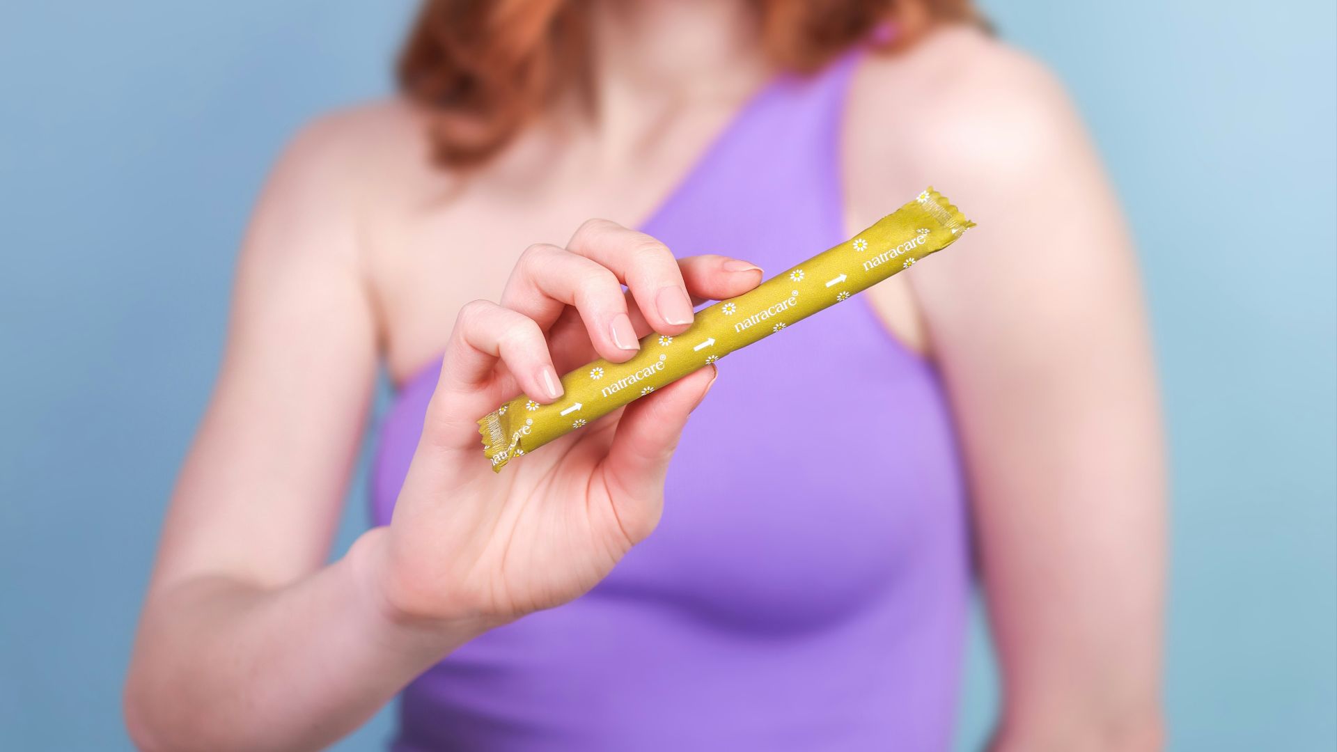A woman in a purple top holding a piece of food