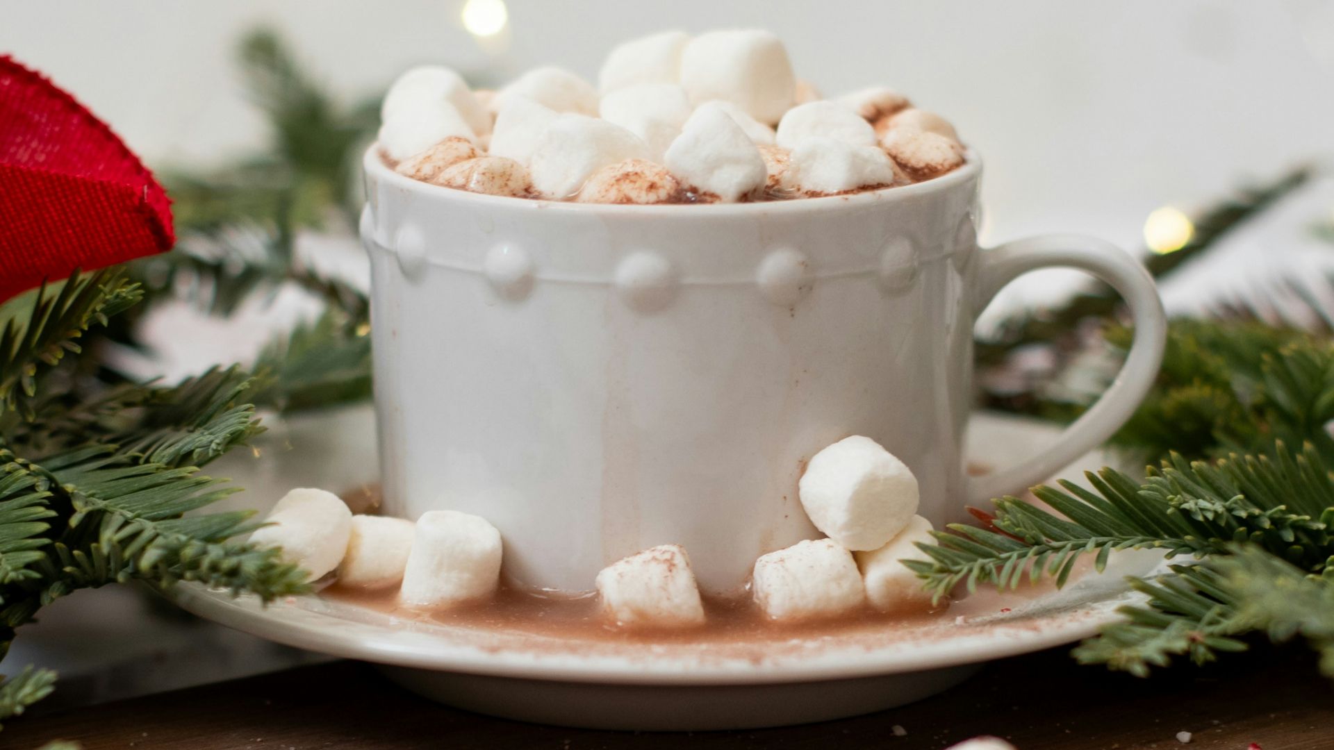 a cup of hot chocolate and marshmallows on a cutting board