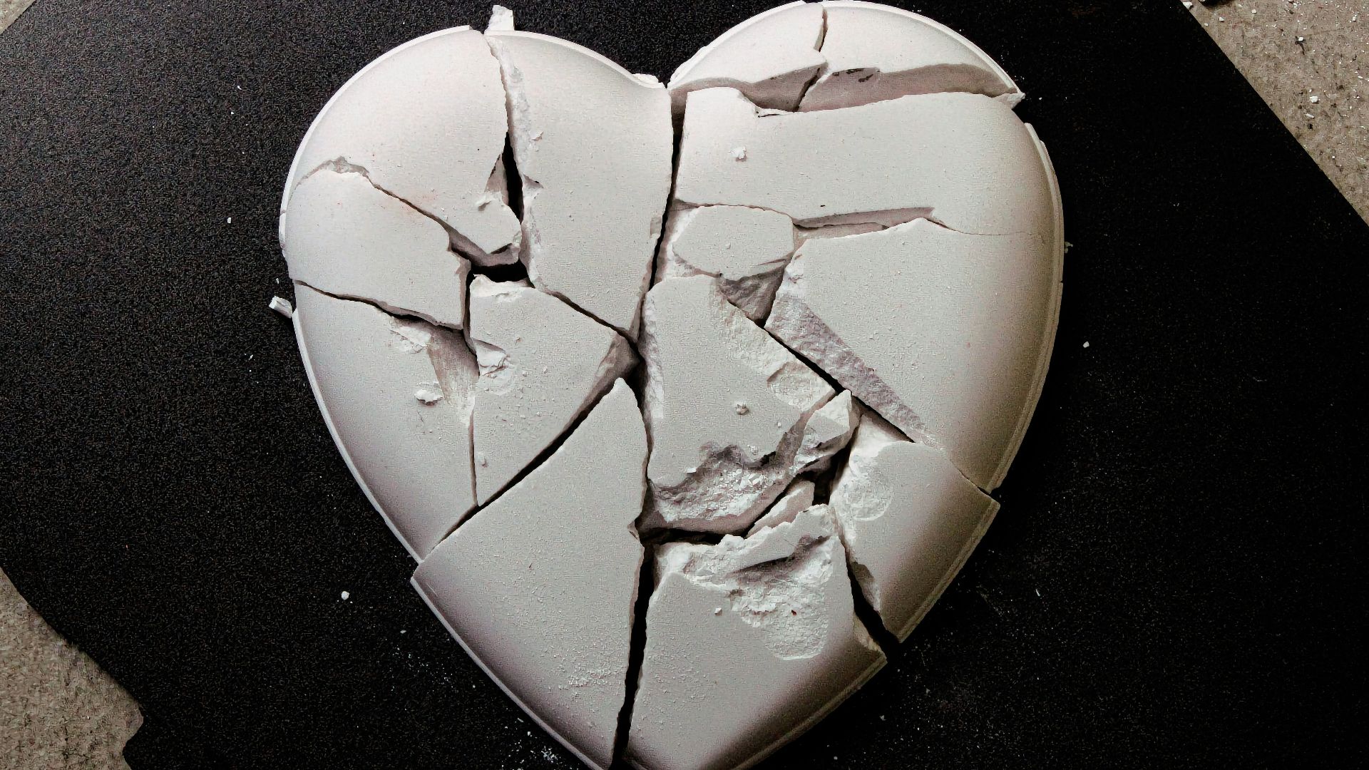 A broken heart shaped cookie sitting on top of a table