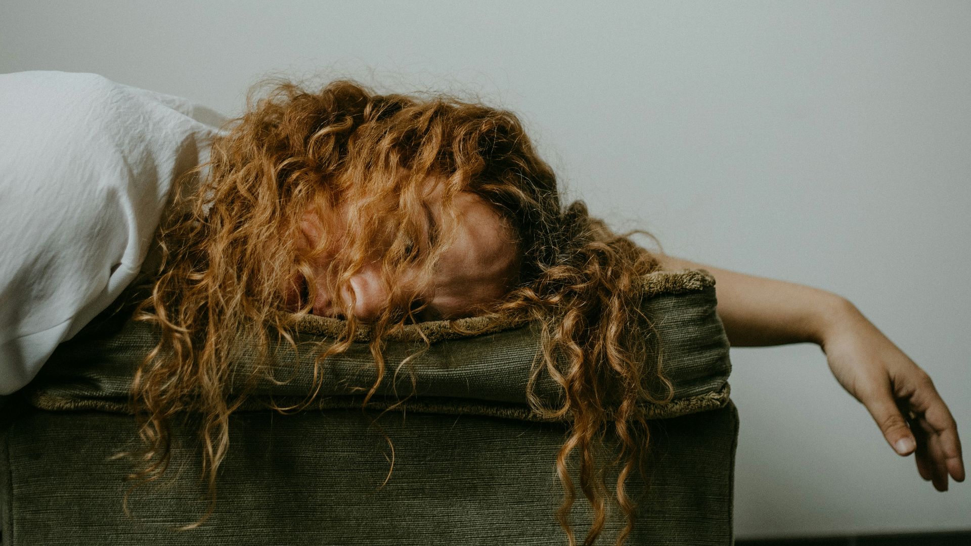 woman in white shirt lying on black textile
