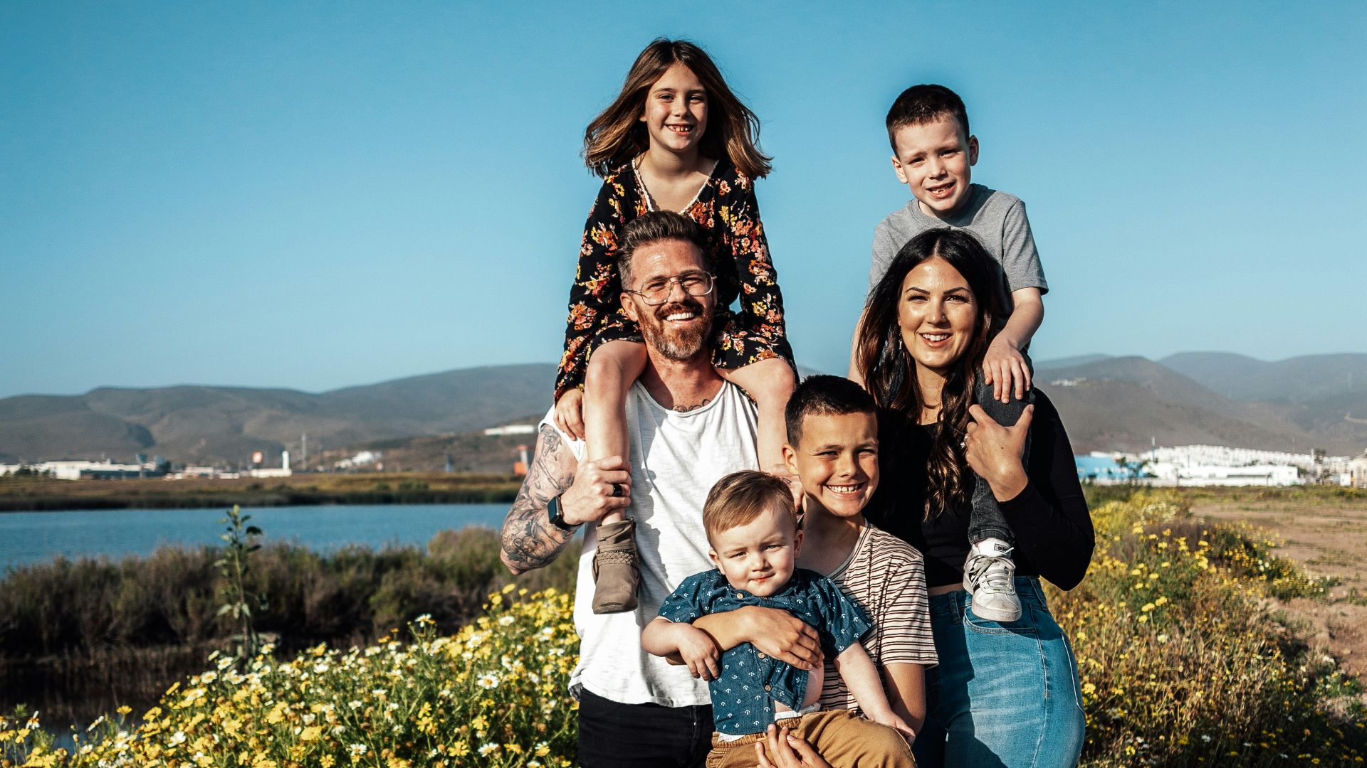 2 women and man standing on green grass field during daytime