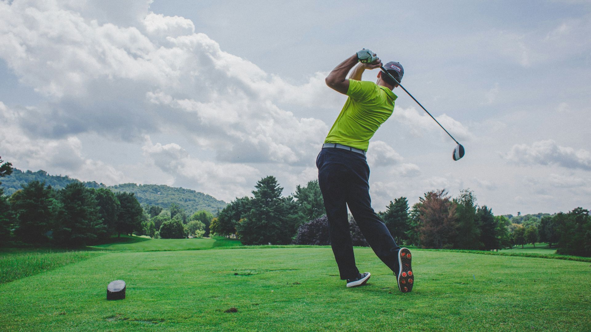 photo of man swinging golf driver