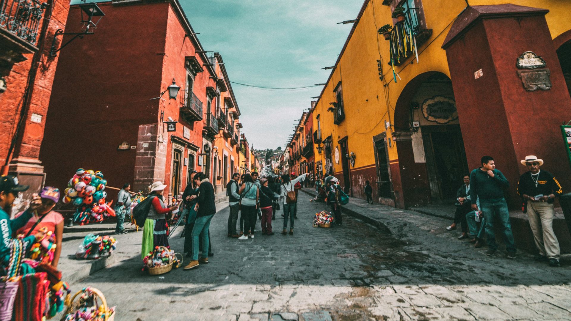 people standing on corner road near concrete buildings during daytime