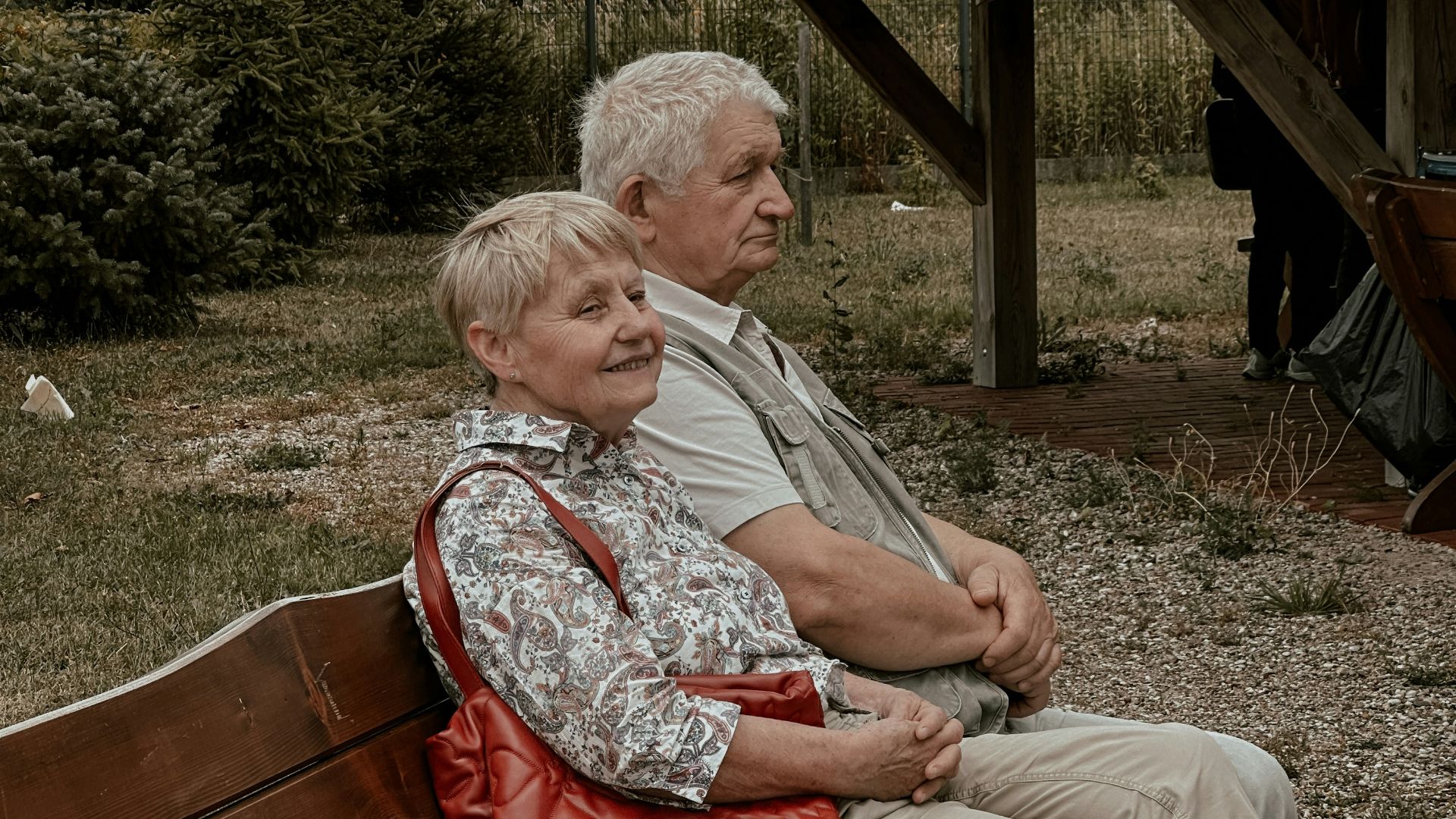 a man and a woman sitting on a wooden bench