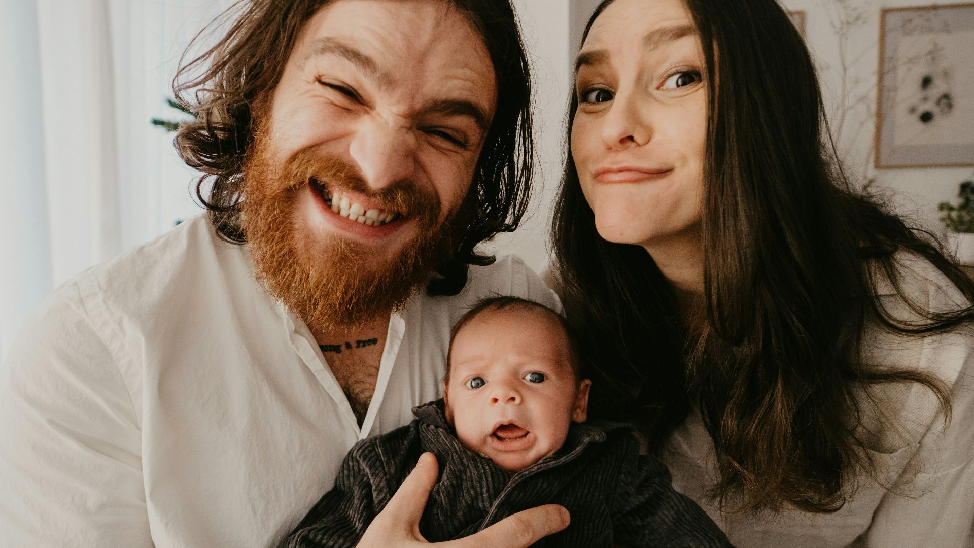 a man and woman holding a baby in their arms