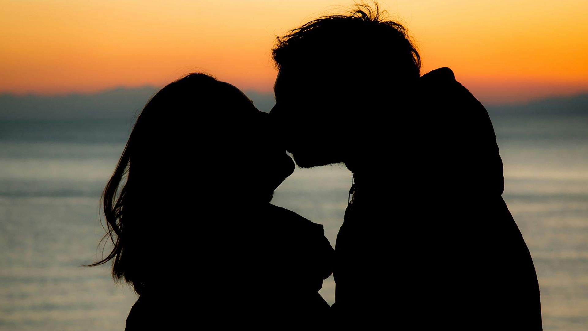 silhouette of couple kissing during sunset