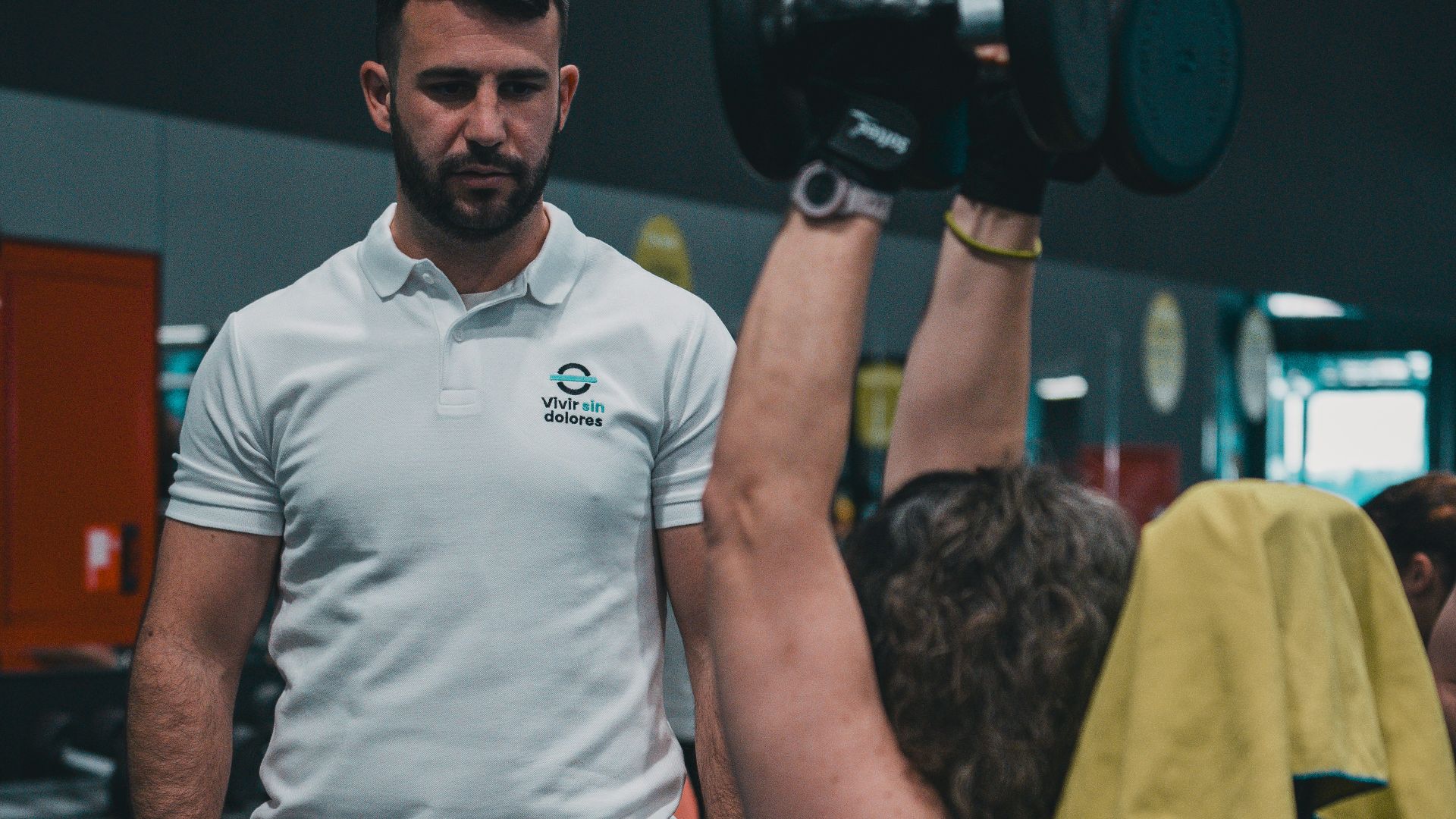 A man lifting a barbell in a gym