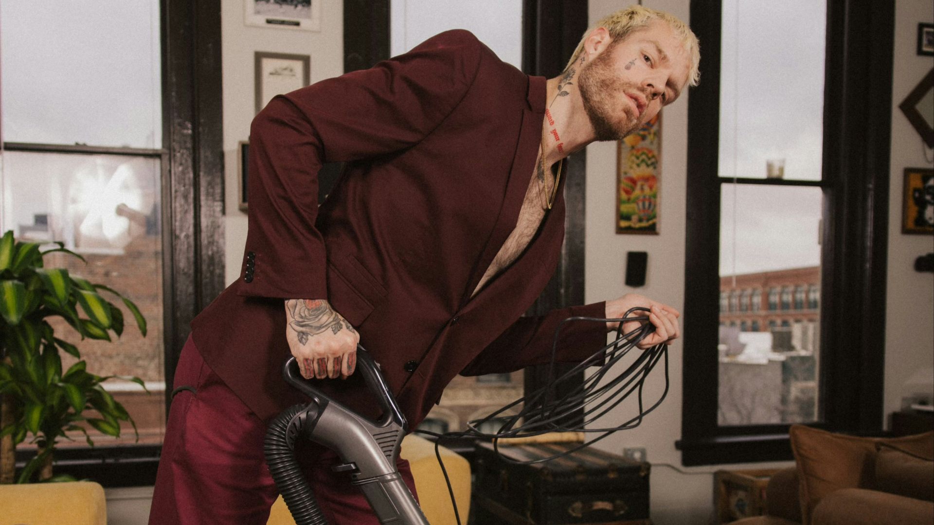 a man in a red suit is using a vacuum