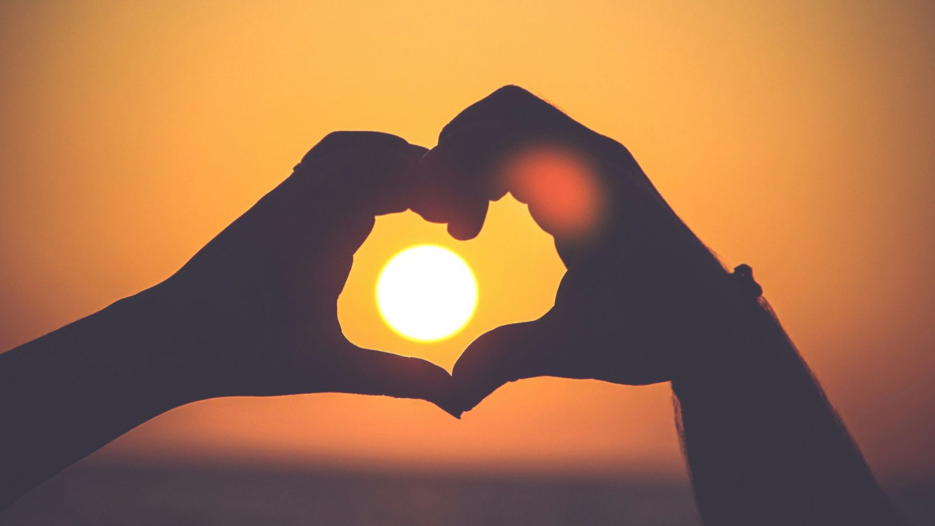 silhouette of person's hands forming heart