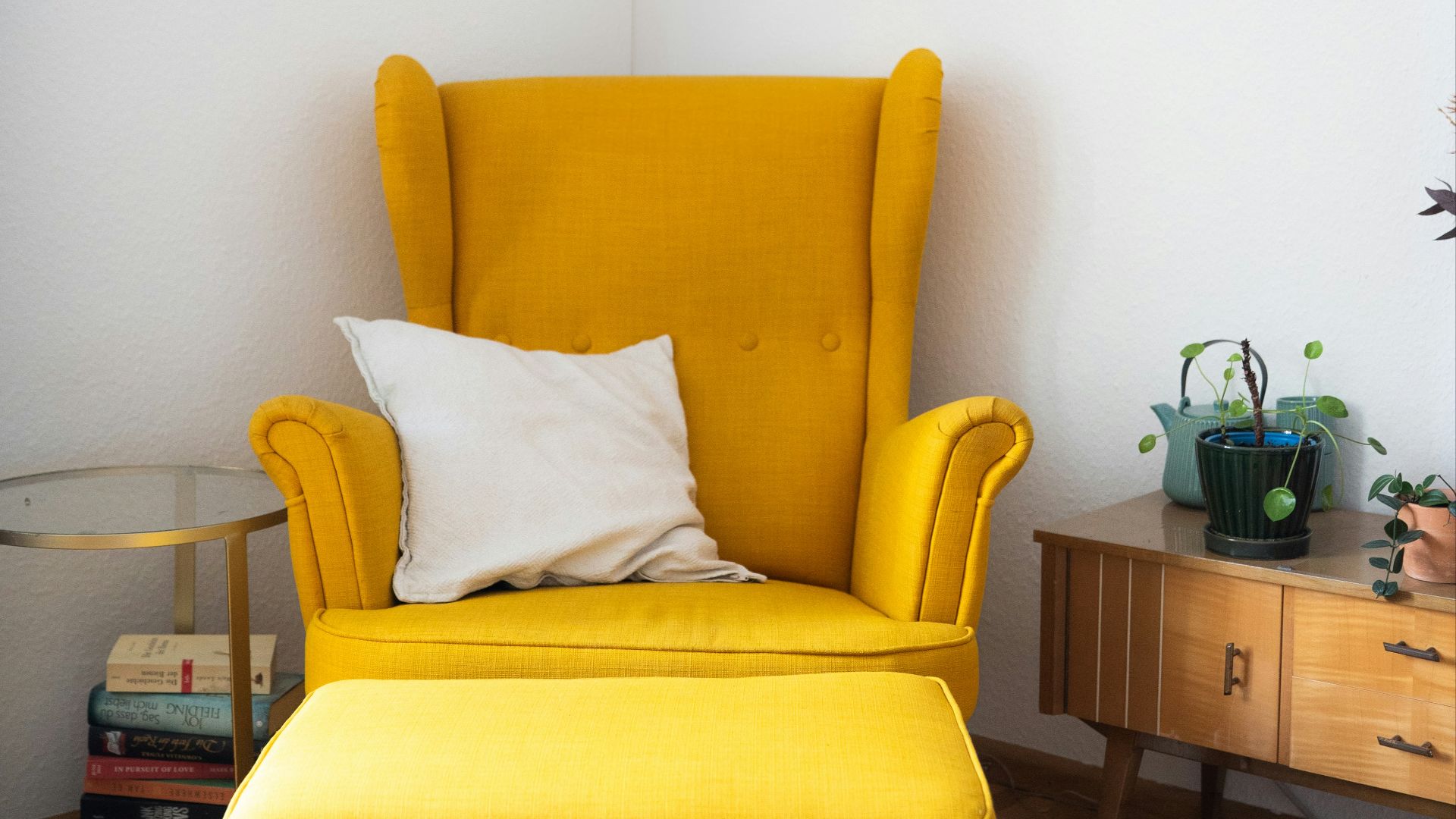 Cozy yellow chair and ottoman in a bright corner.