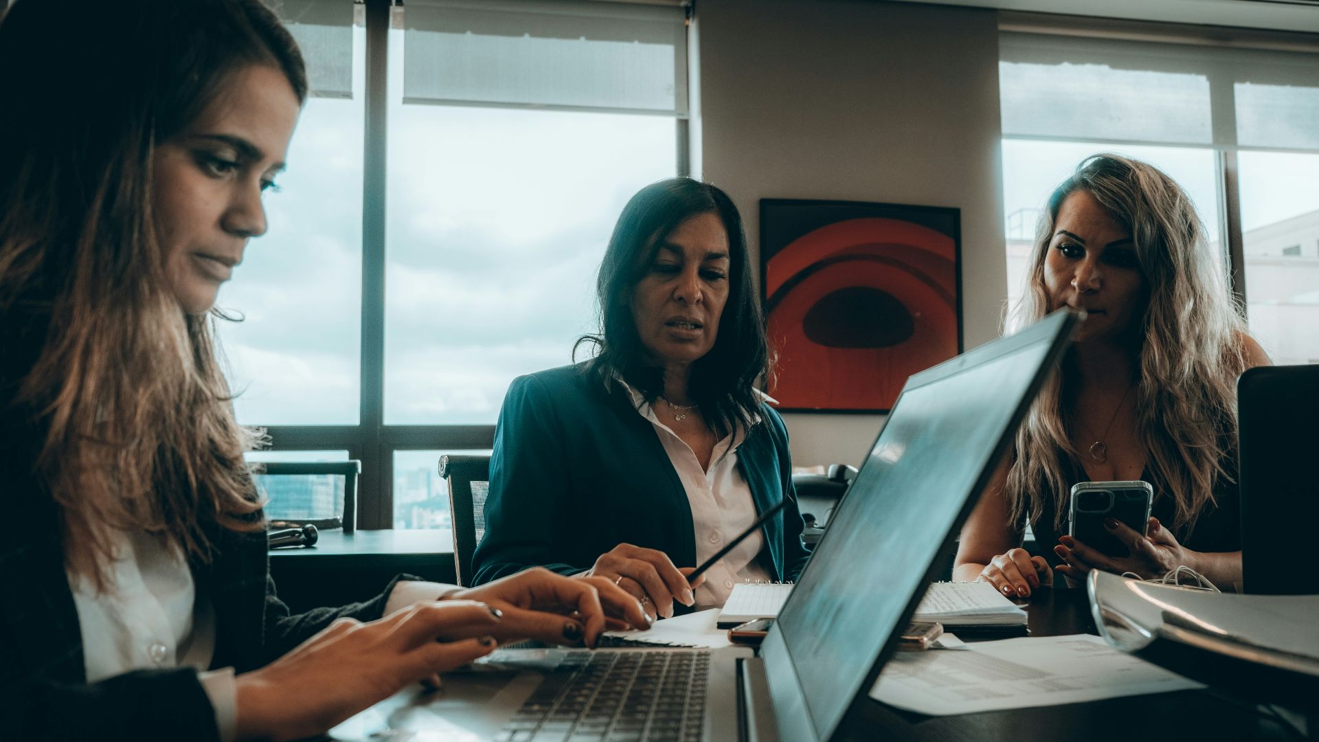 a group of women sitting around a laptop computer