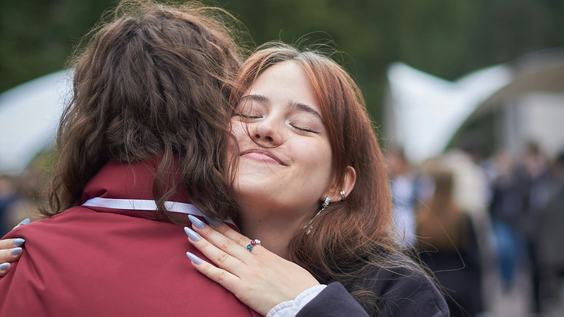 Two people embracing outdoors with smiles