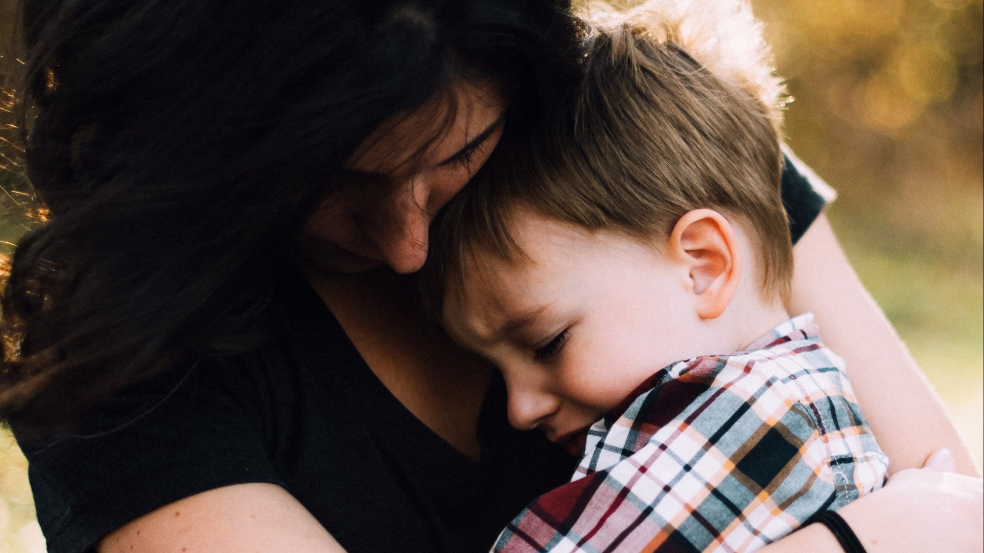 woman hugging boy on her lap