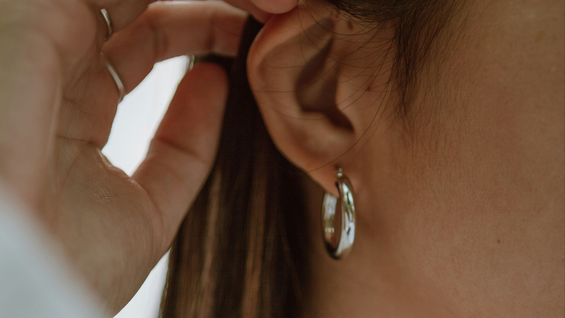 woman in white shirt wearing gold necklace