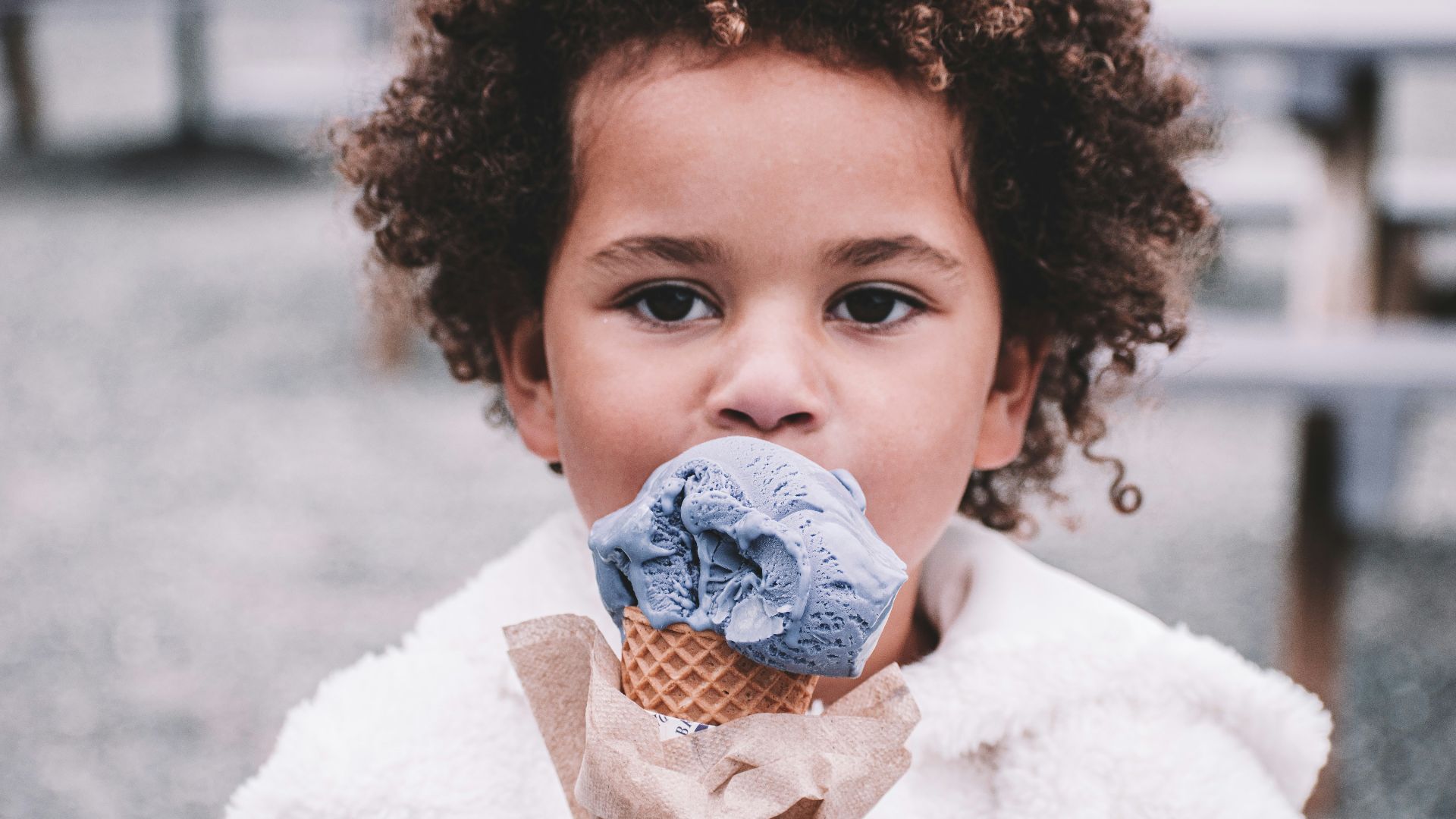 girl in white sweater holding ice cream