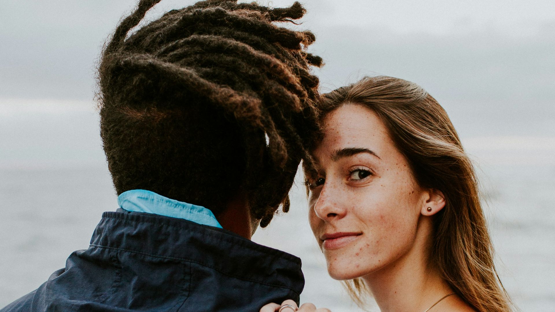 woman in blue long sleeve shirt beside woman in gray long sleeve shirt