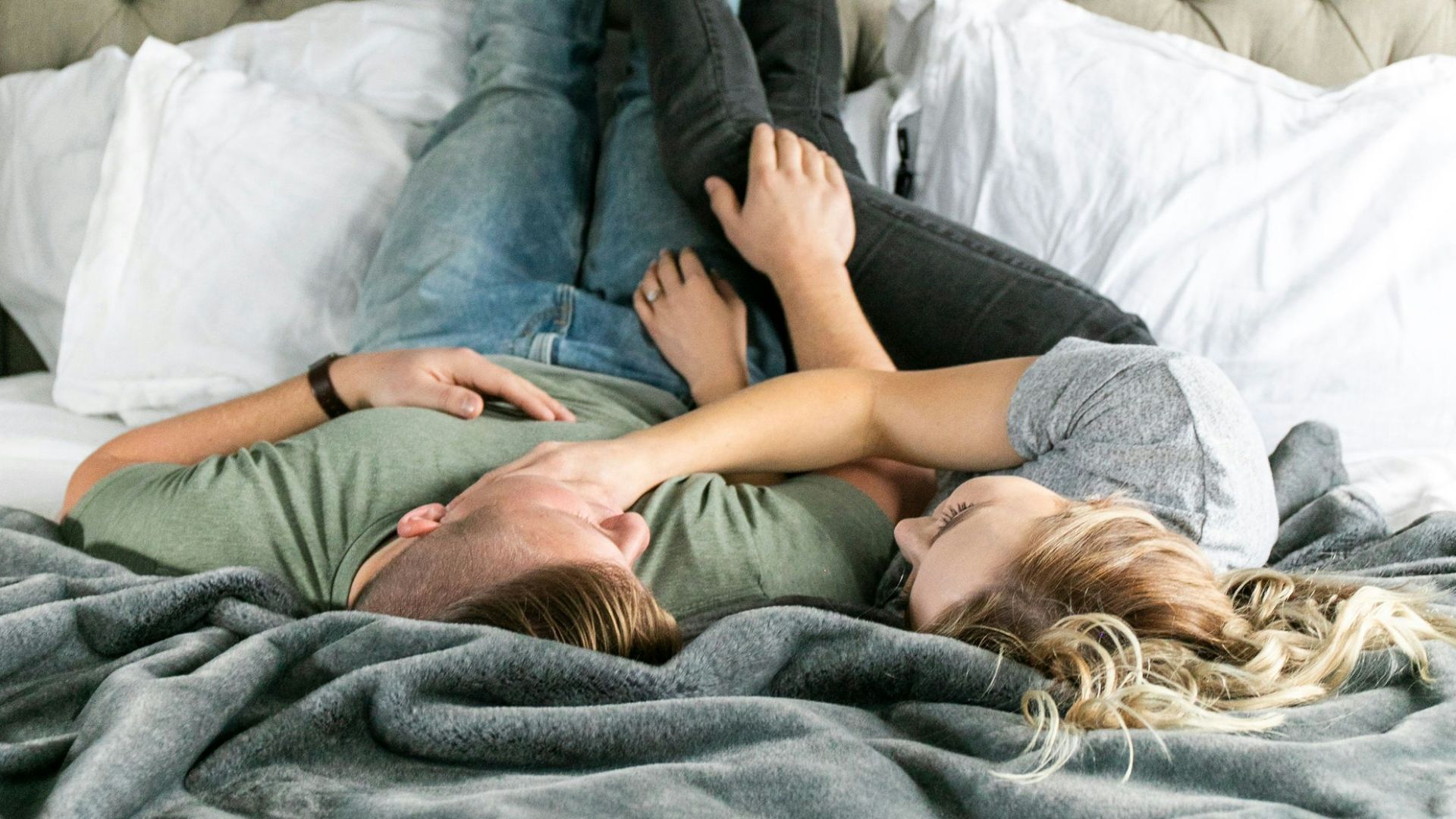 woman in blue denim jeans lying on bed