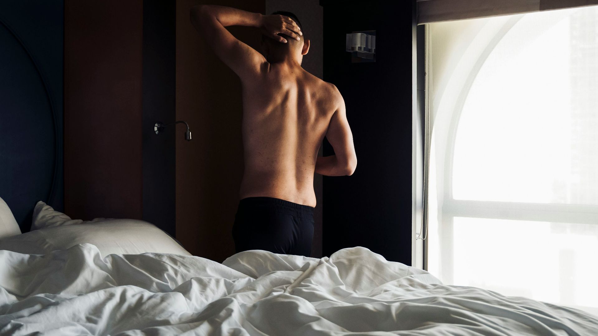 person in black shorts lying on bed