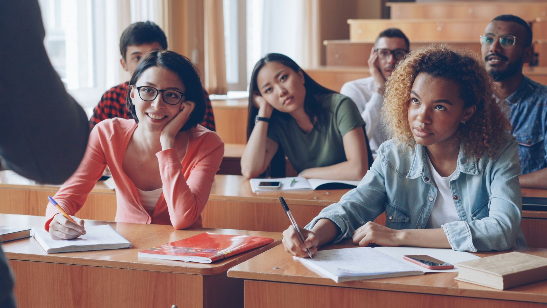 Students attentively listening in a lecture hall.