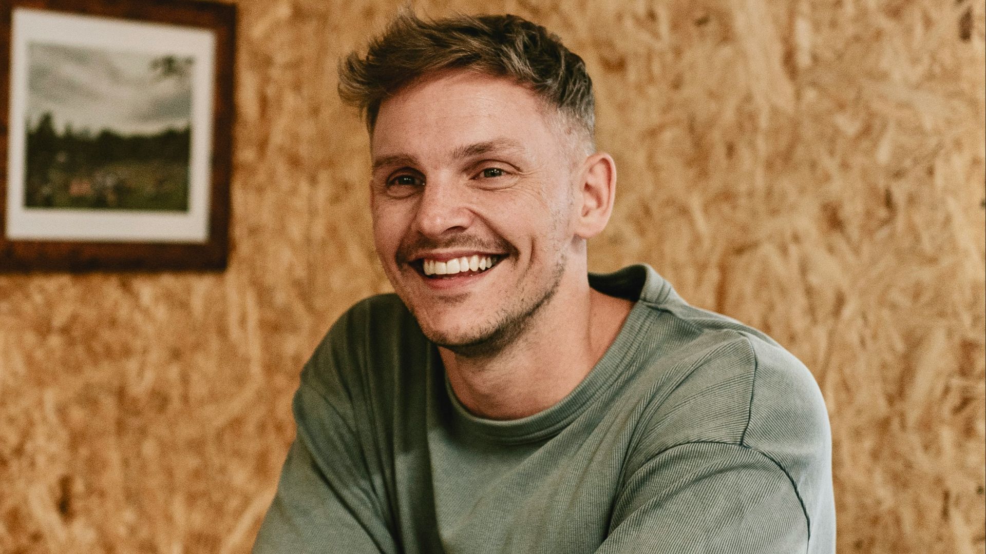 A man sitting at a table with a pool cue in his hand