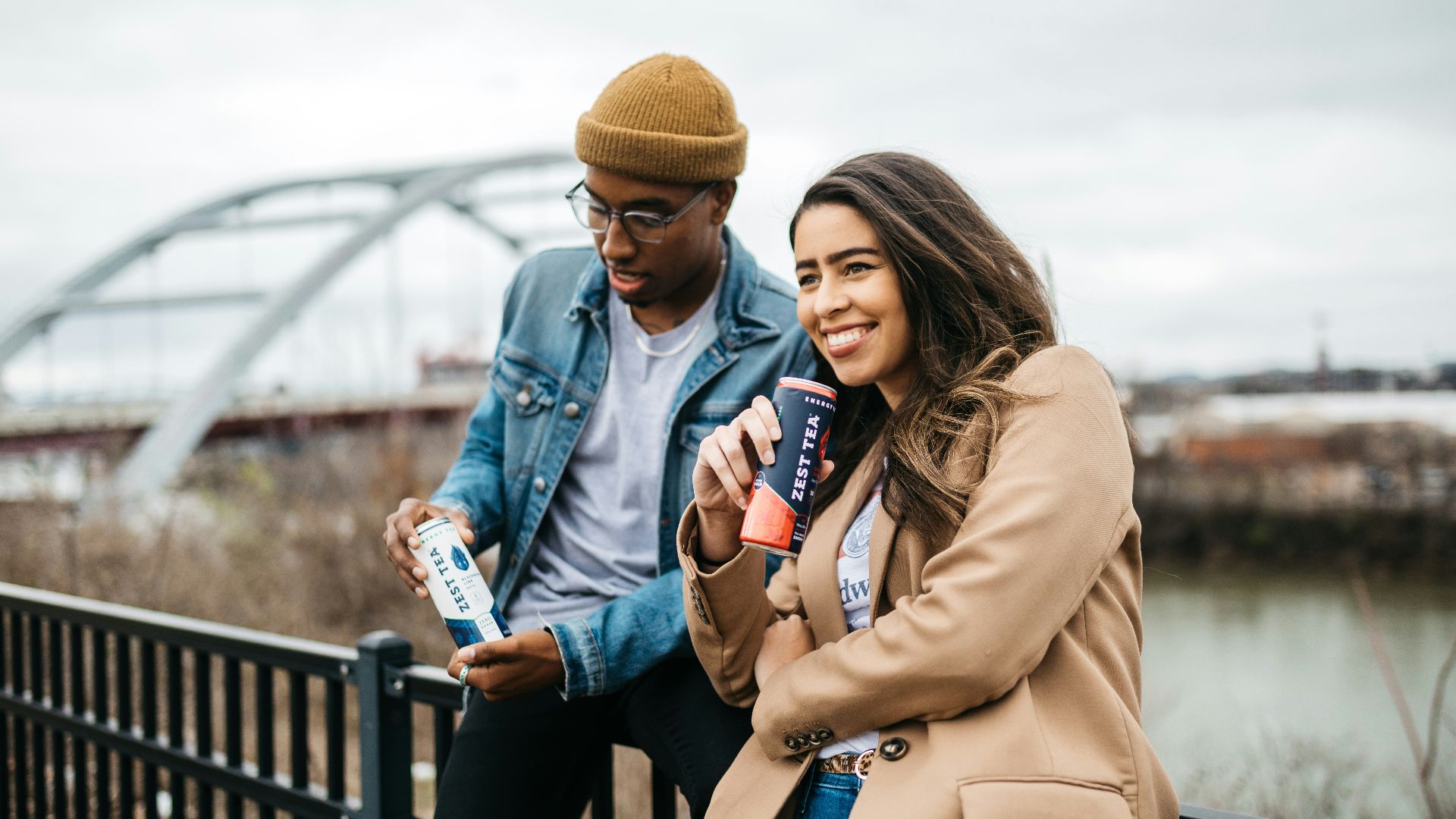 woman in brown coat holding white and blue labeled bottle
