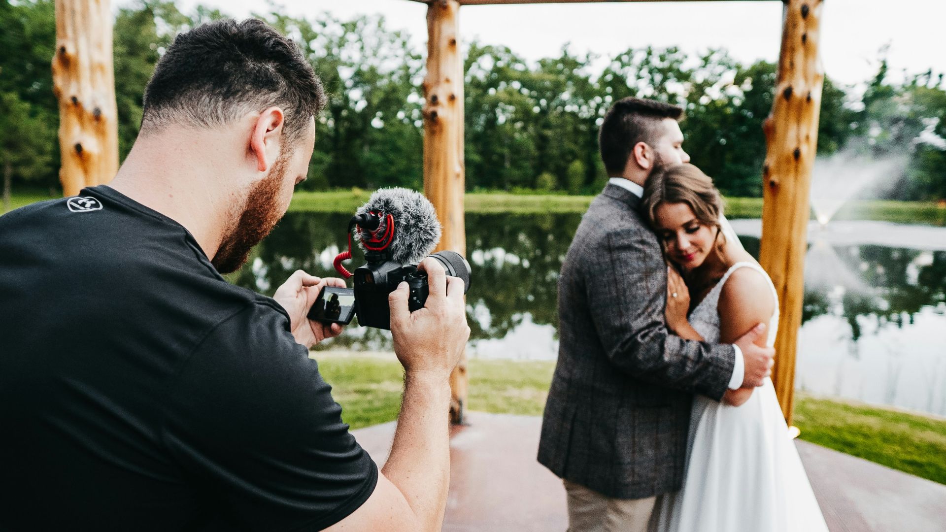 man in black t-shirt holding black dslr camera