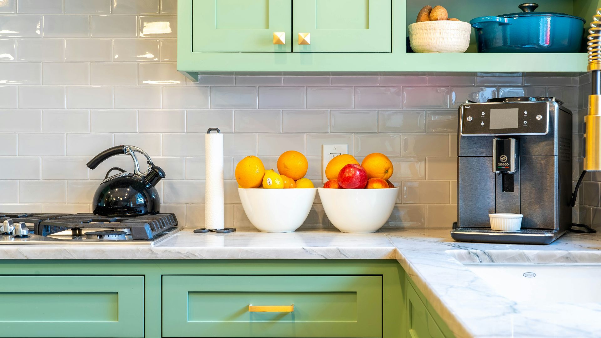 a kitchen with green cabinets and white counter tops