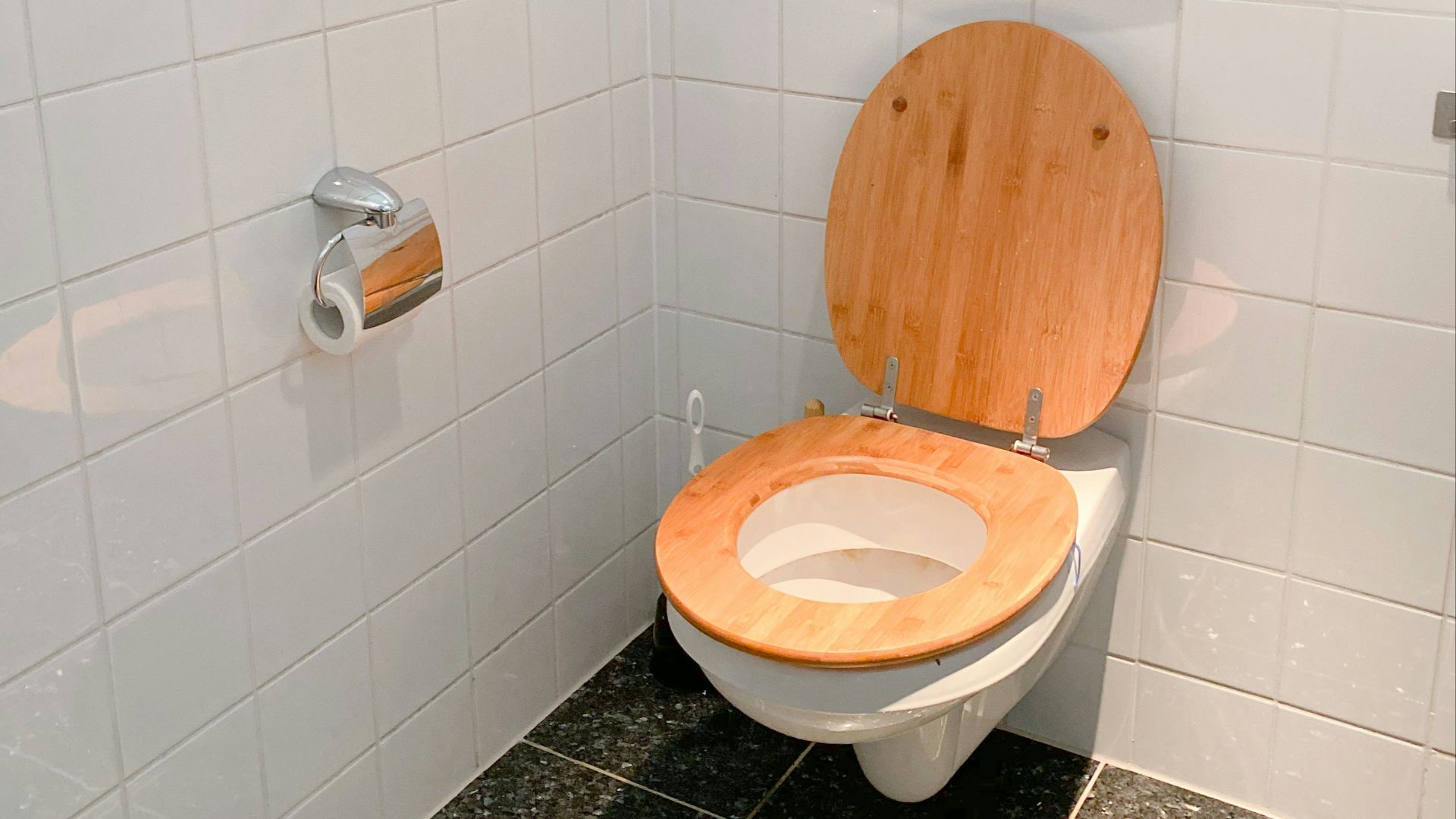 white ceramic toilet bowl beside white ceramic wall tiles