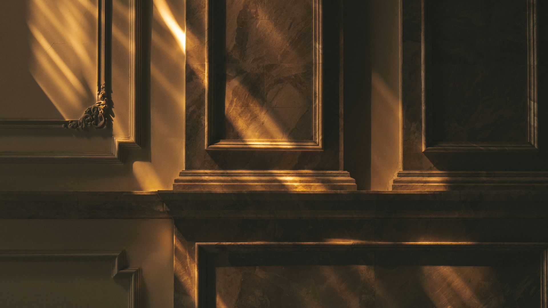 Sunlight streams across ornate marble wall panels.
