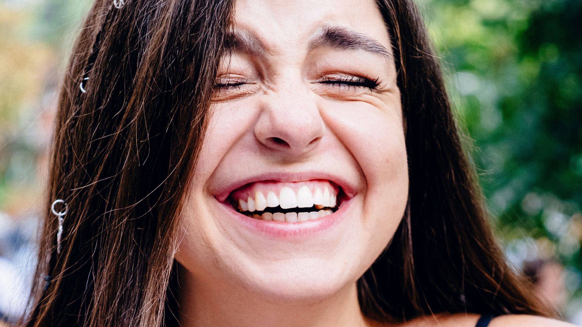 woman in black spaghetti strap top smiling