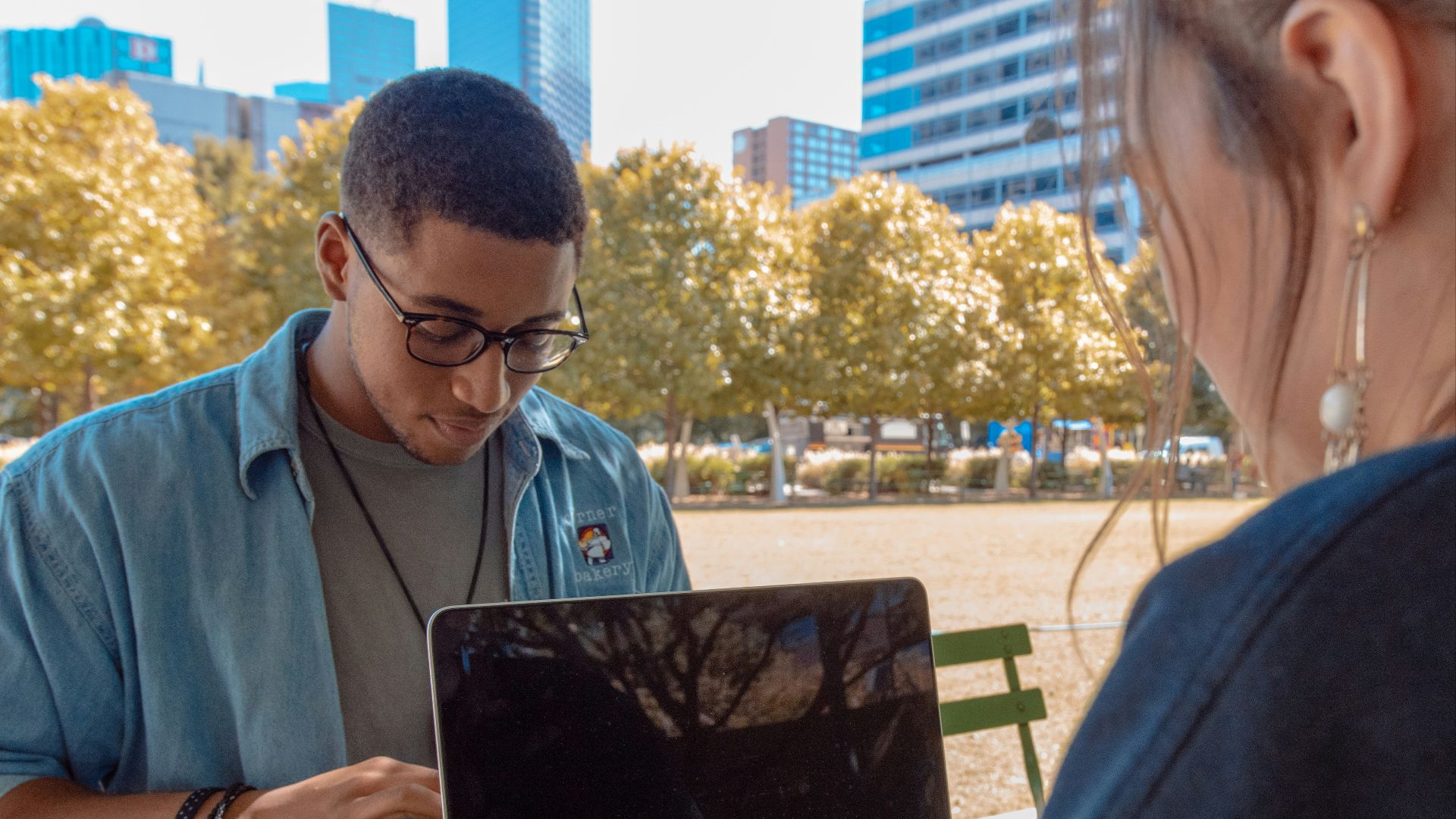 man and woman sitting while using MacBook Pro