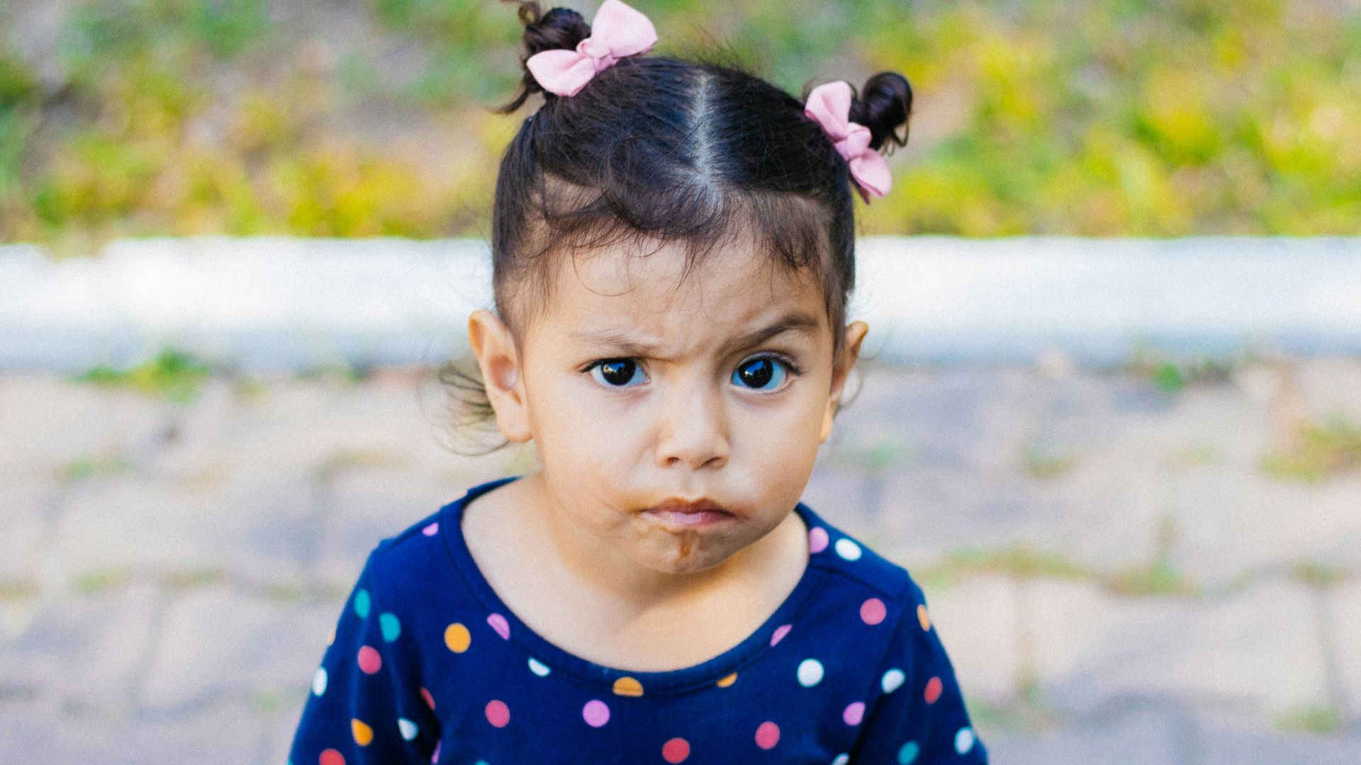 a little girl with a donut in her mouth