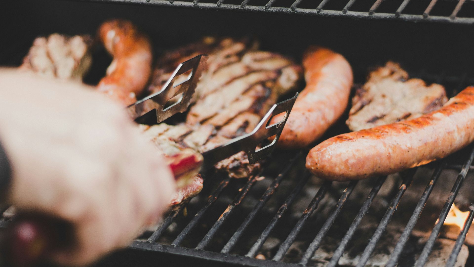 person grilling sausage and meat