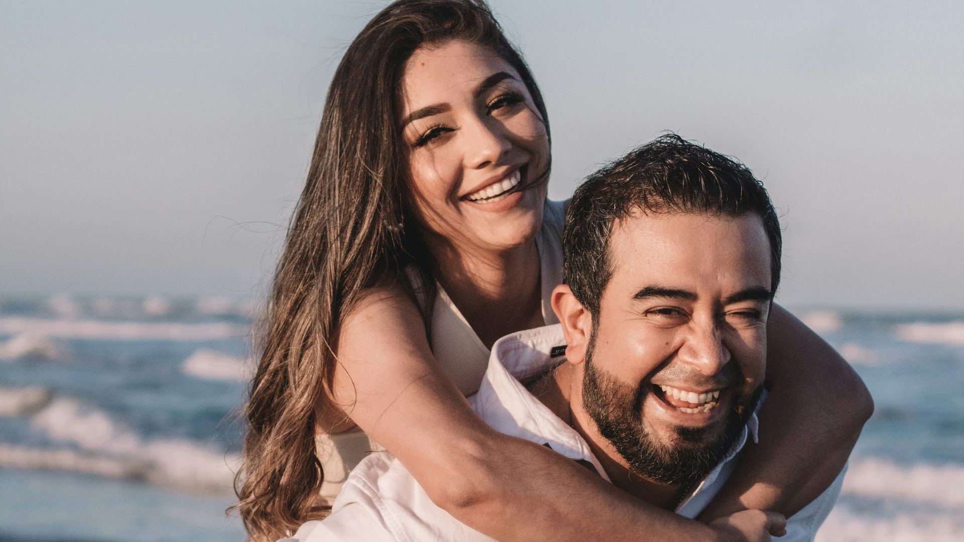 man in white dress shirt hugging woman in white dress