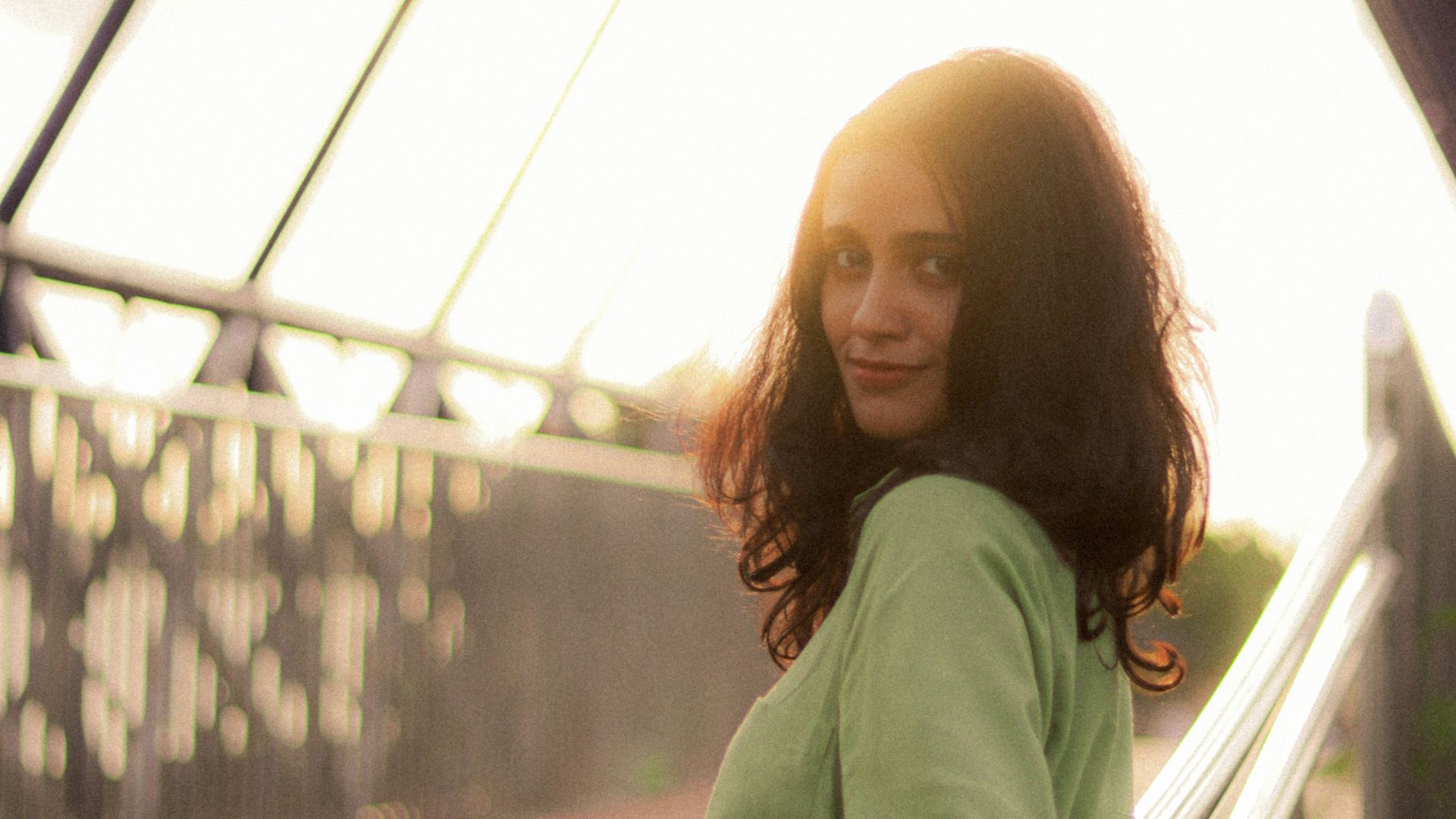 Woman in a green shirt on a bridge