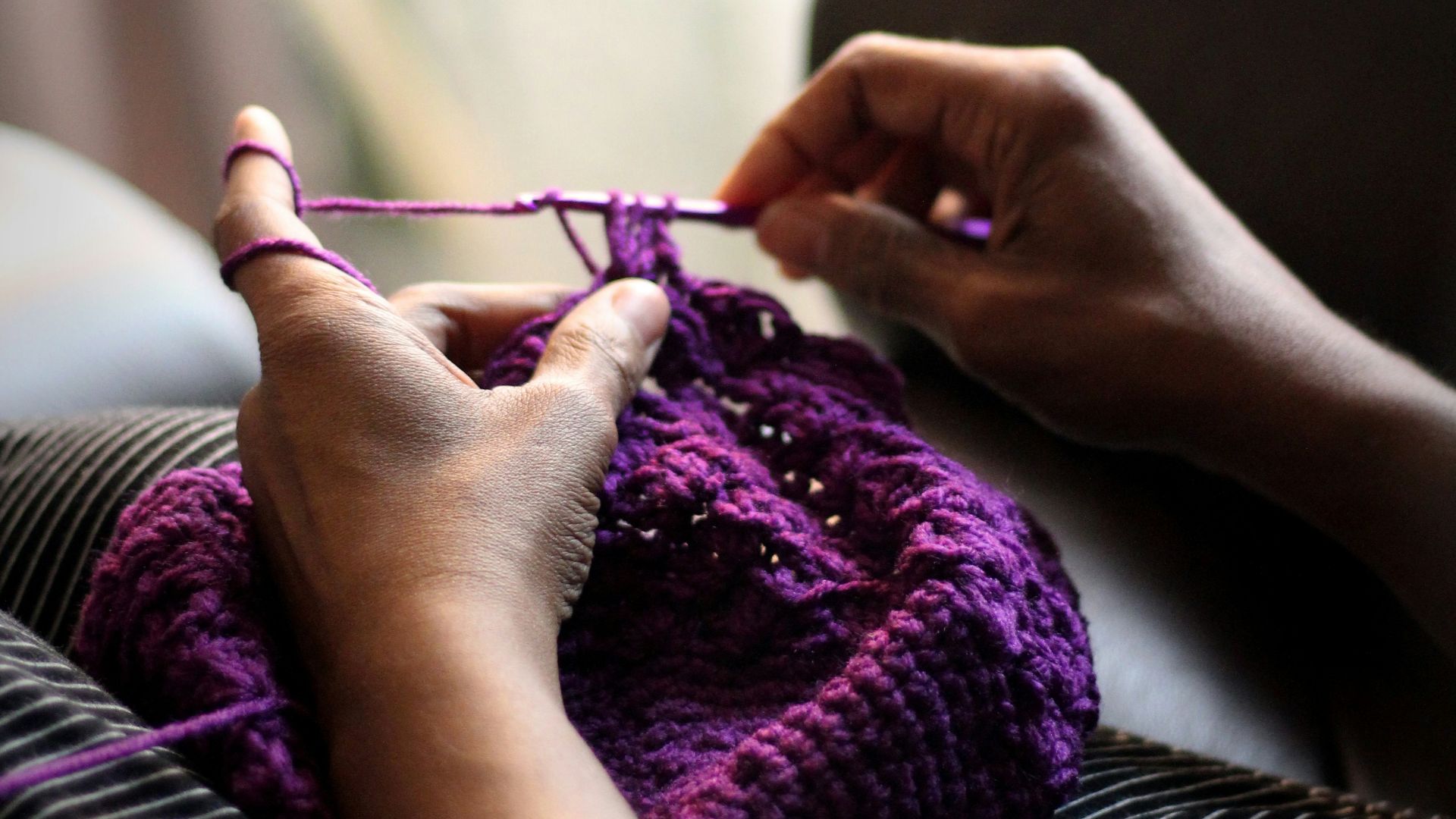 woman sewing purple textile