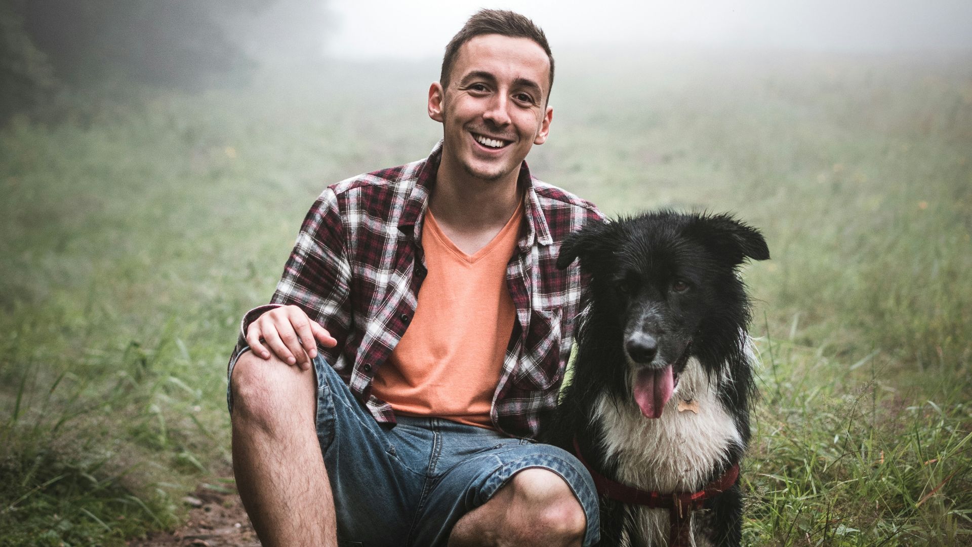 man sitting beside black dog