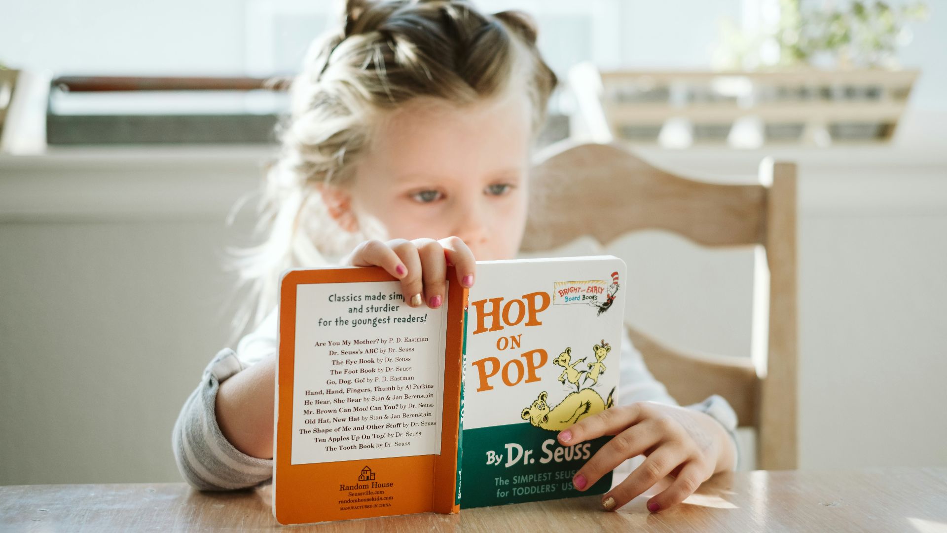 girl sitting while reading book