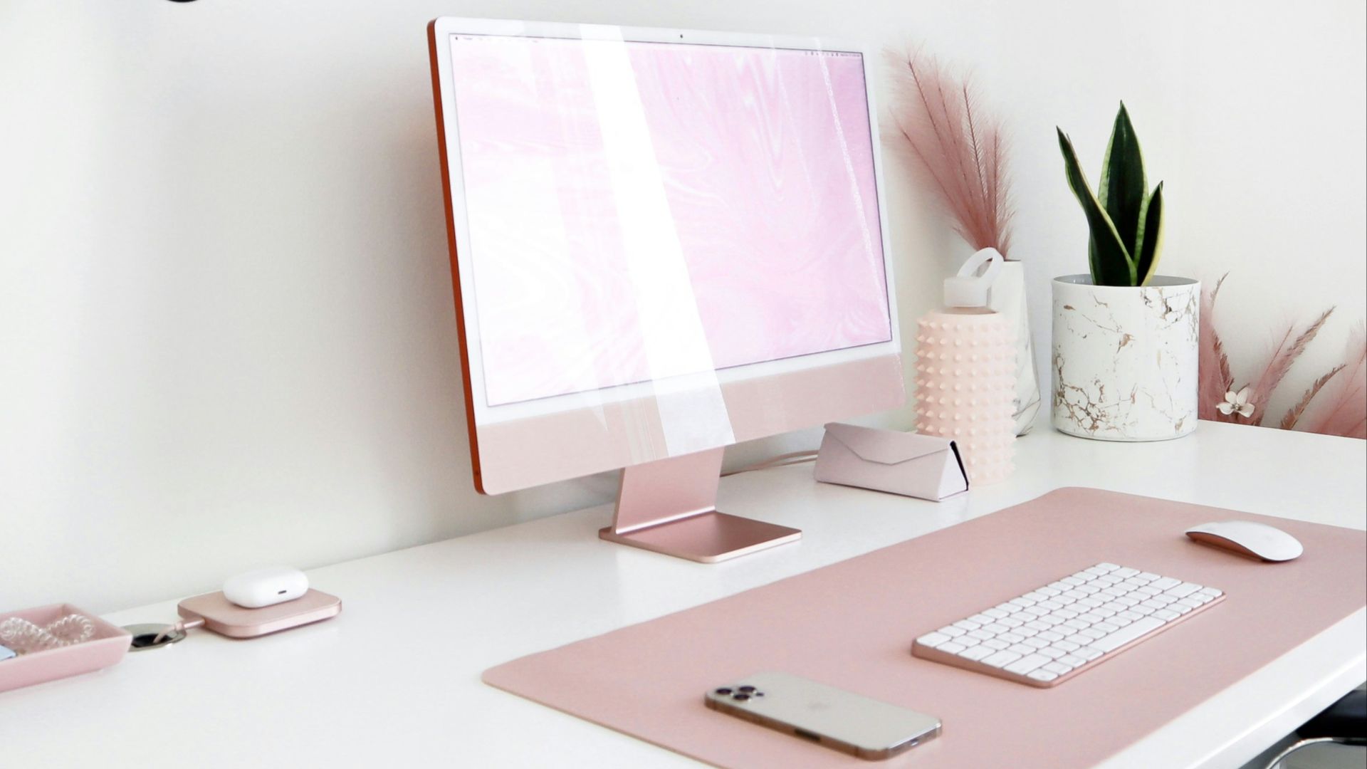 a white desk with a pink computer on it