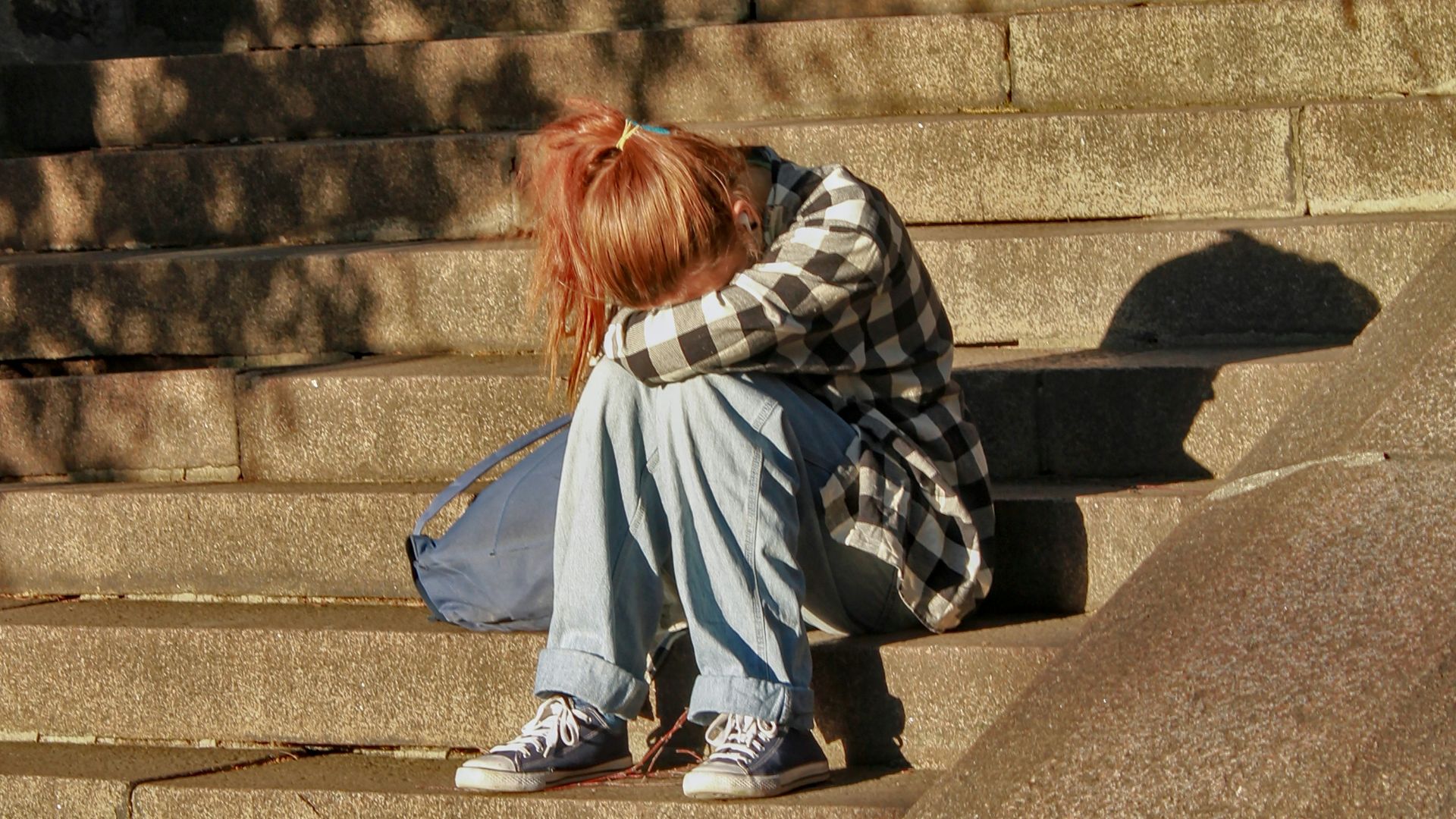 woman in black and white dress sitting on concrete stairs