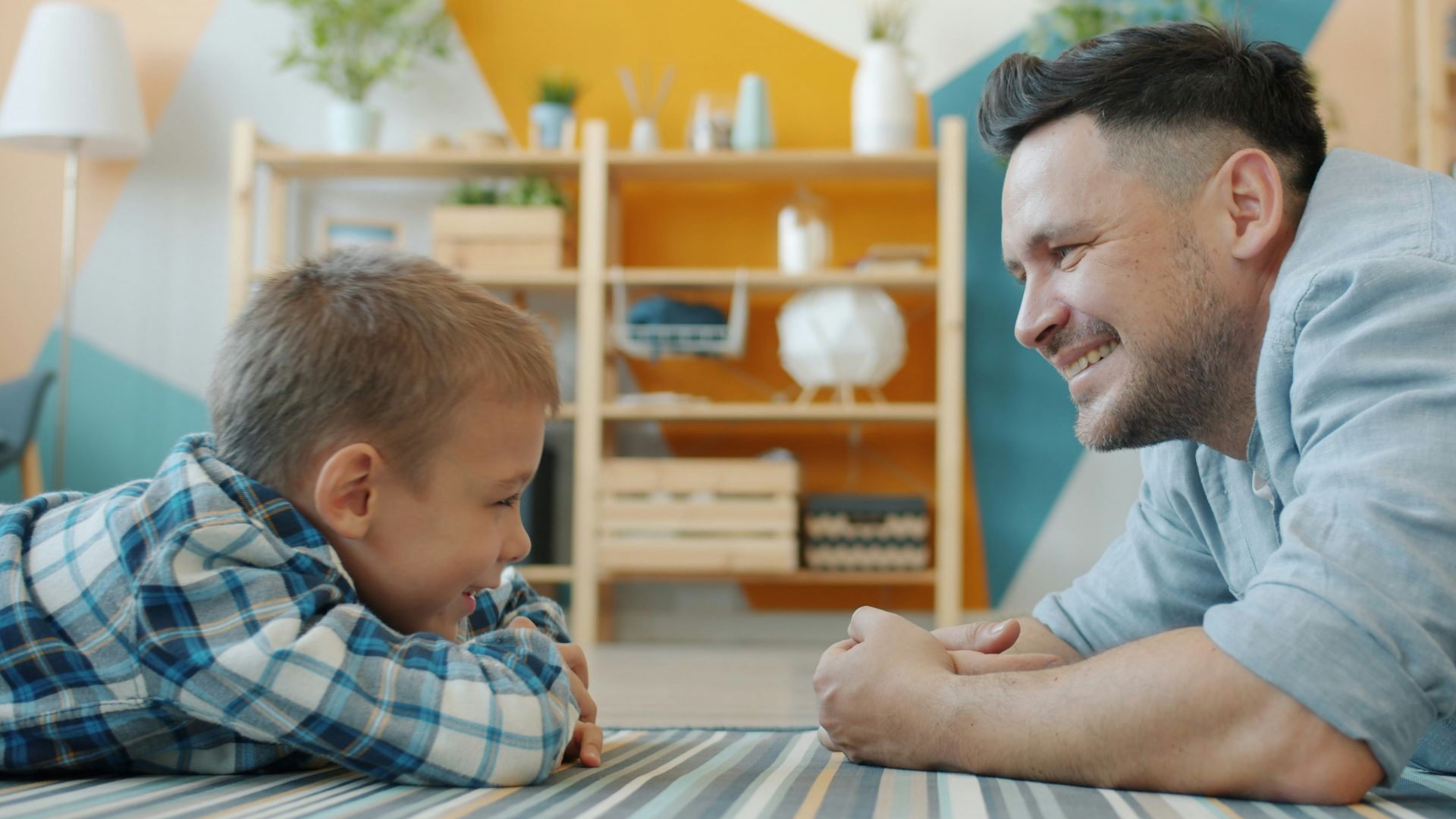 Father and son lying on floor talking